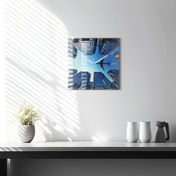 Wanduhr quadratisch mit motiv Flugzeug über Gebäuden